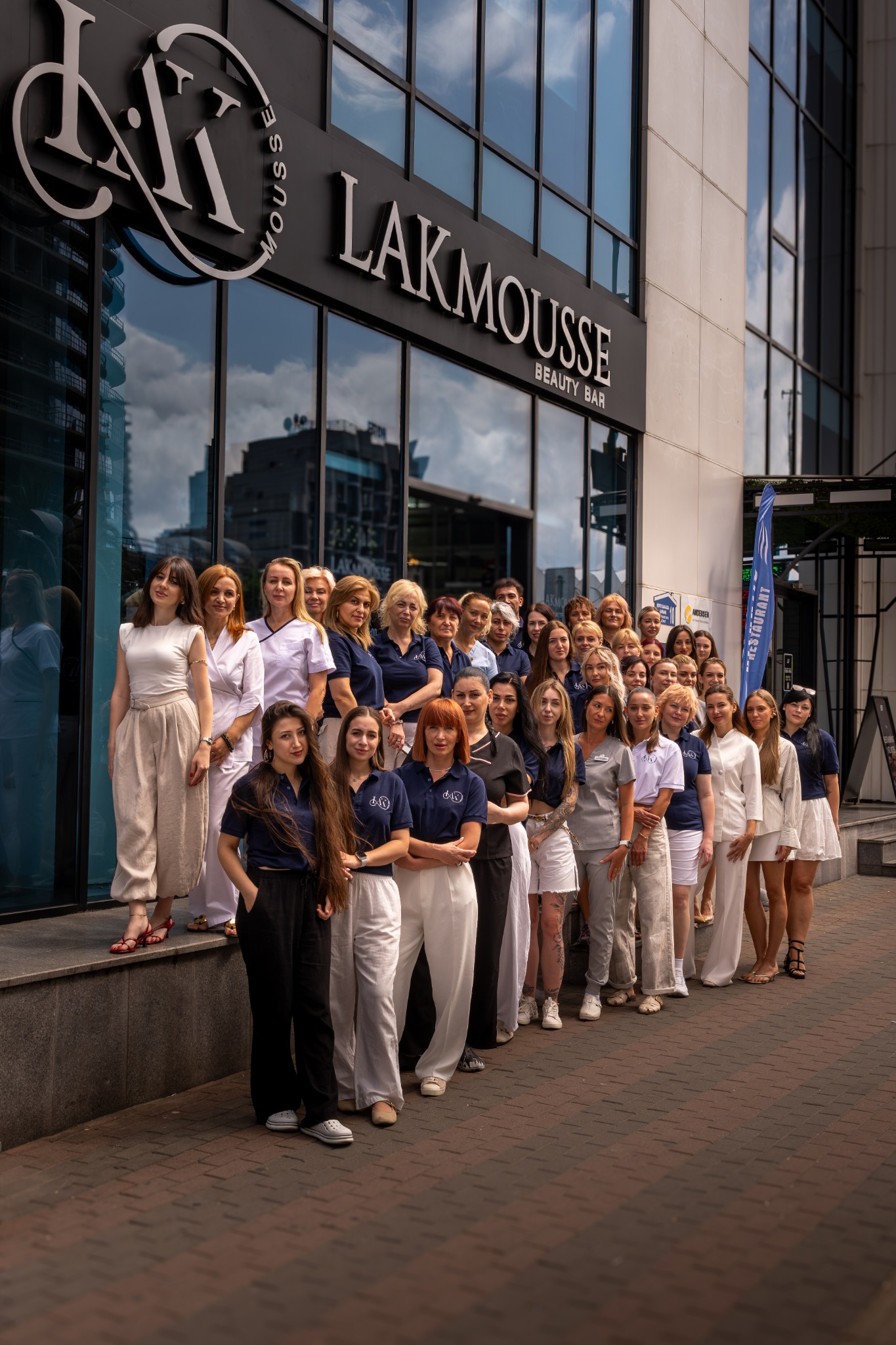 Коллектив LAKmousse Beauty Bar на фоне фасада и вывески салона в Батуми